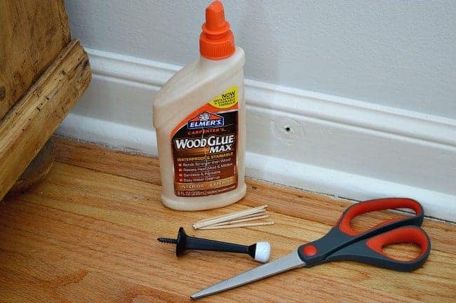 wood glue, toothpicks, door stop and scissors on wood floor