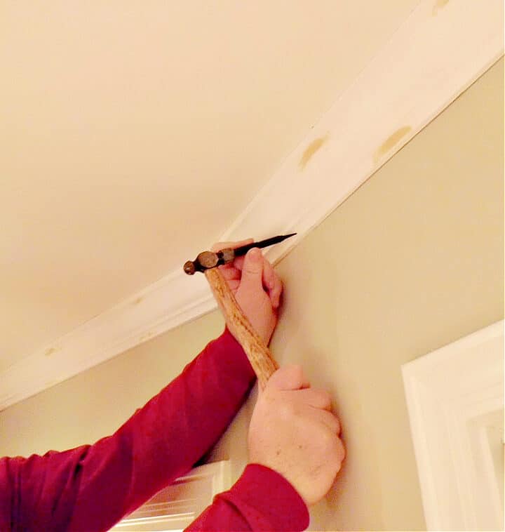 Installing Crown Molding shot using nail set to finish crown molding