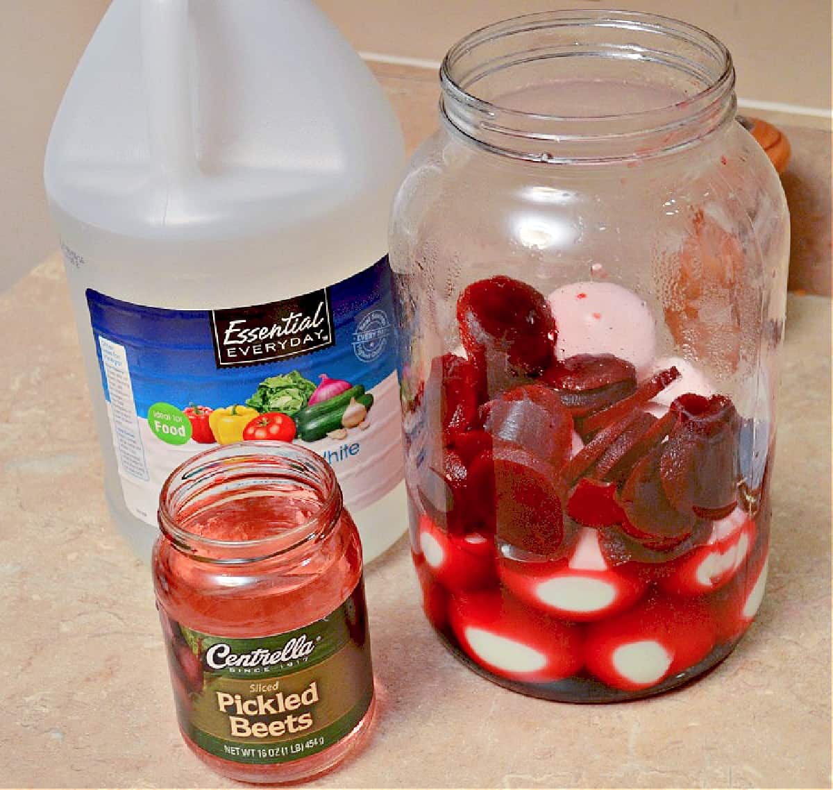 ingredients for pickled eggs including a large har, vinegar and pickled beets