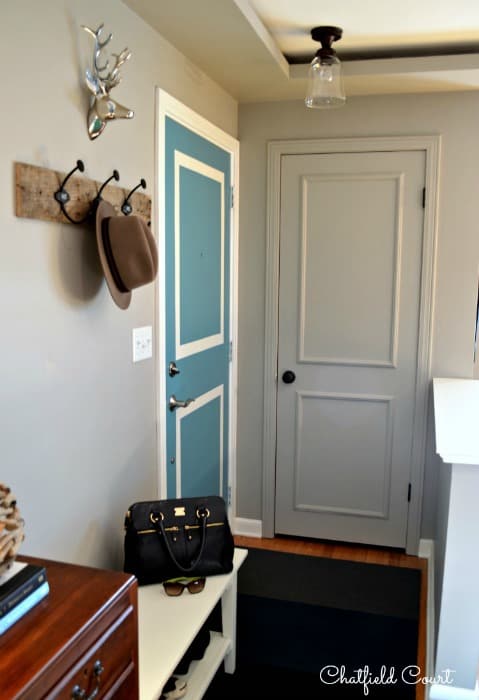 gray painted coat closet door in a small entryway