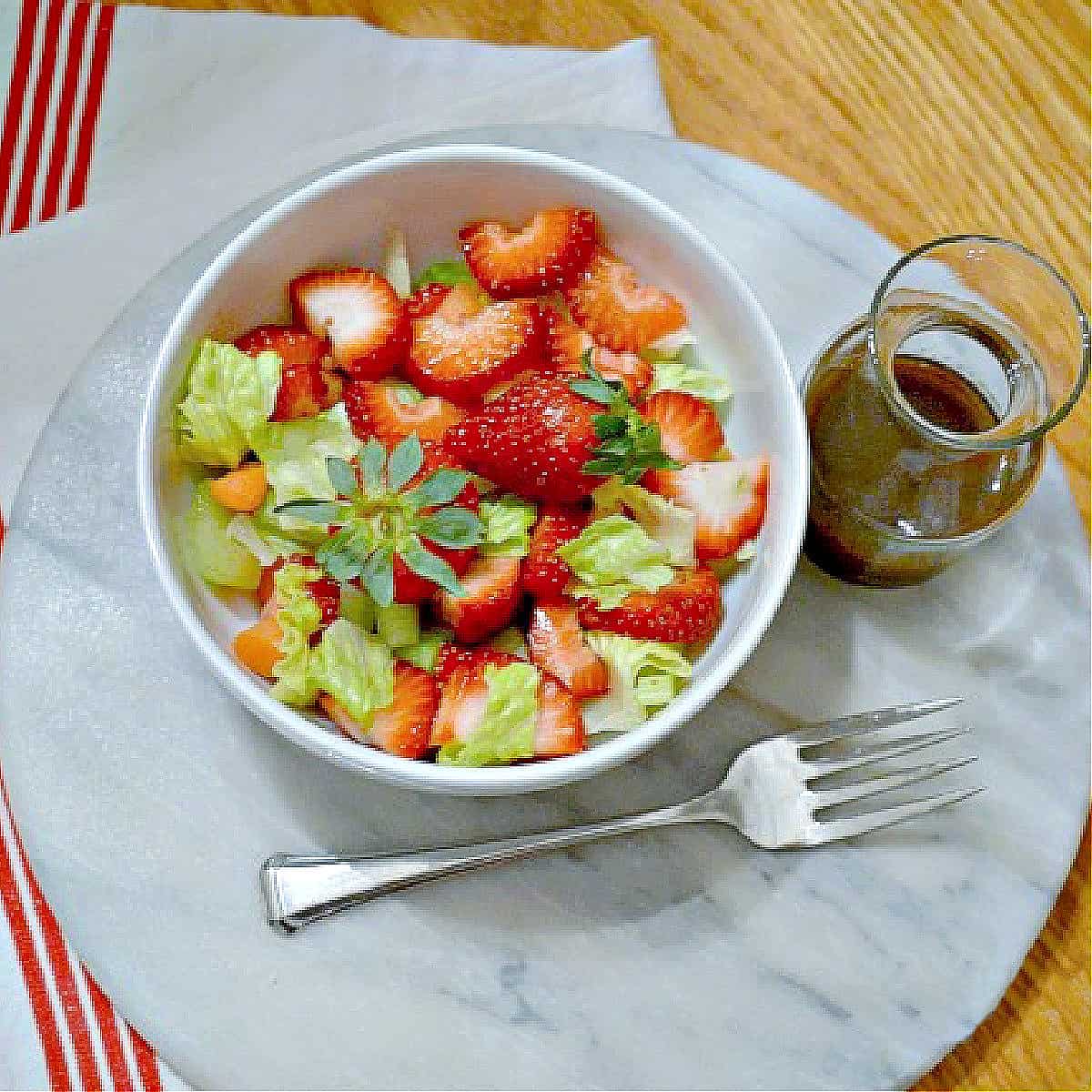 green salad with strawberries and homemade balsamic dressing