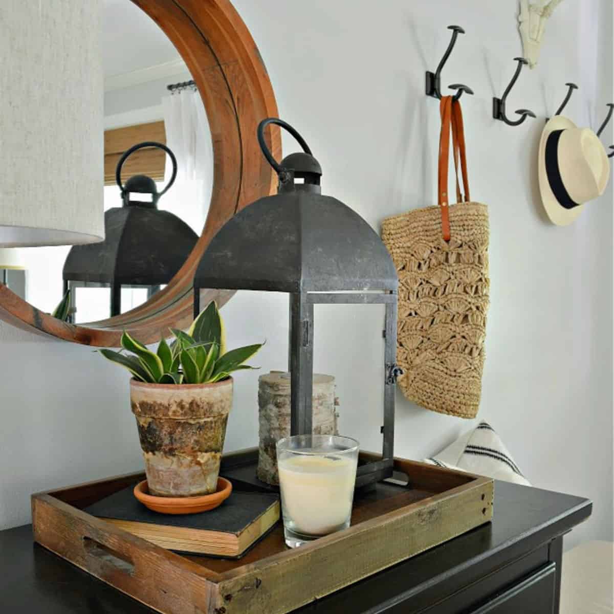 tray with lantern and potted plant on entryway cabinet