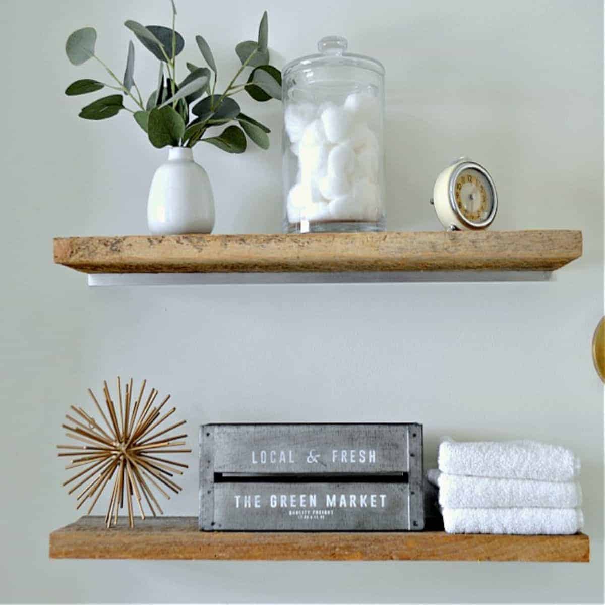 wood shelves in small bathroom with towels and cotton balls on it