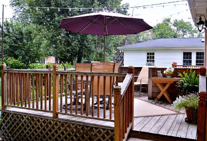 backyard deck with patio umbrella and string lights