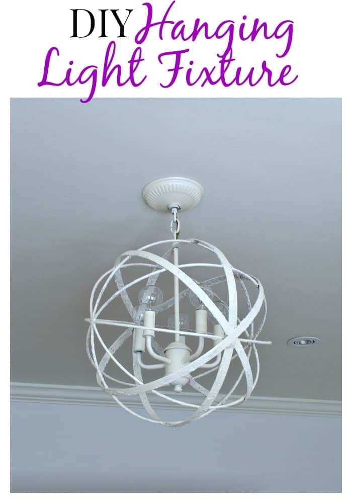 A painted DIY light fixture hanging in a bedroom