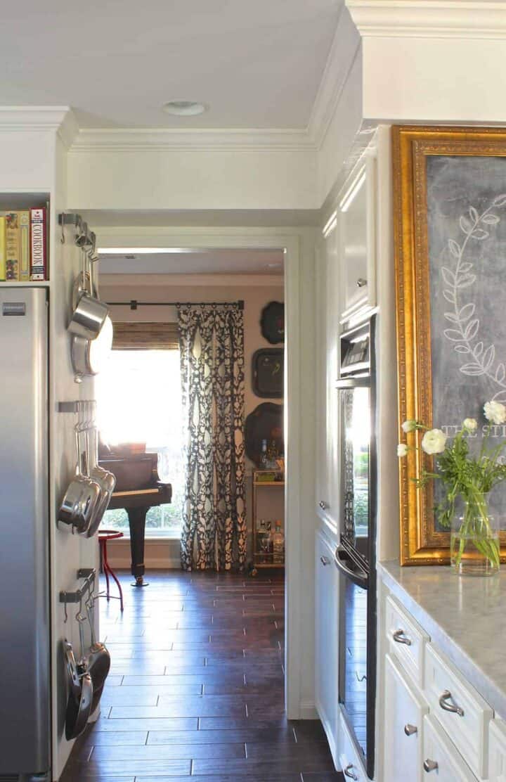 small kitchen pot storage on wall next to refrigerator