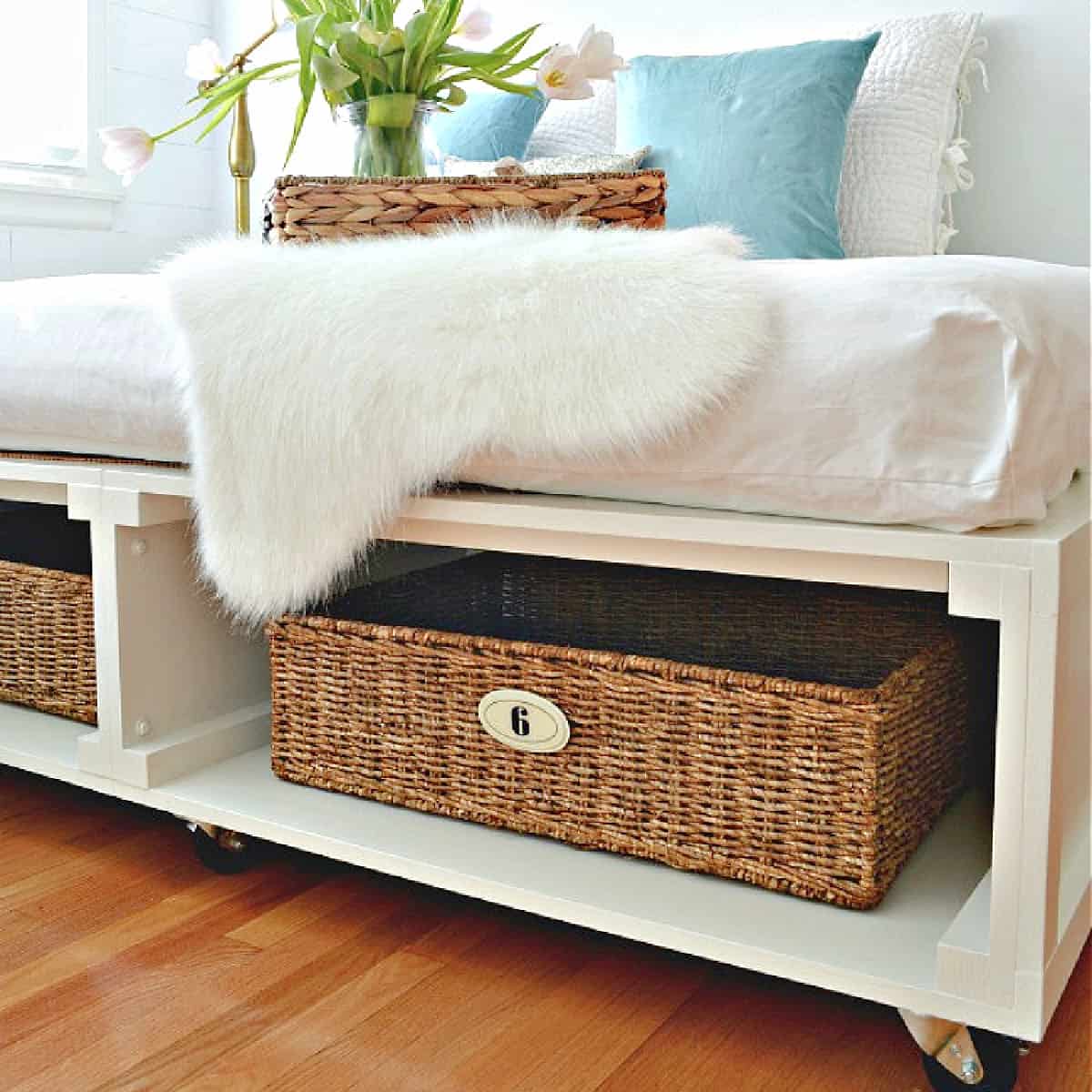 diy white painted platform bed with numbered baskets for storage