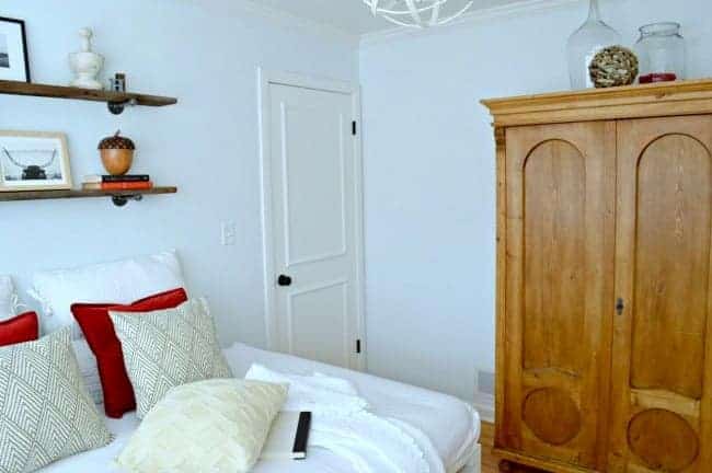 A bedroom with a bed and an armoire