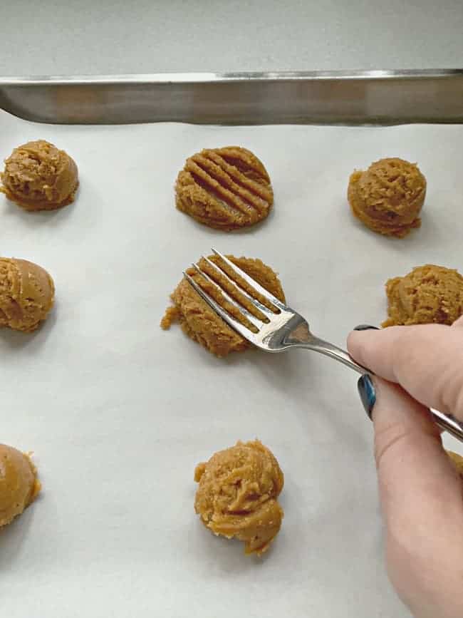 peanut butter cookies baking on a cookie sheet for an easy flourless peanut butter cookie recipe