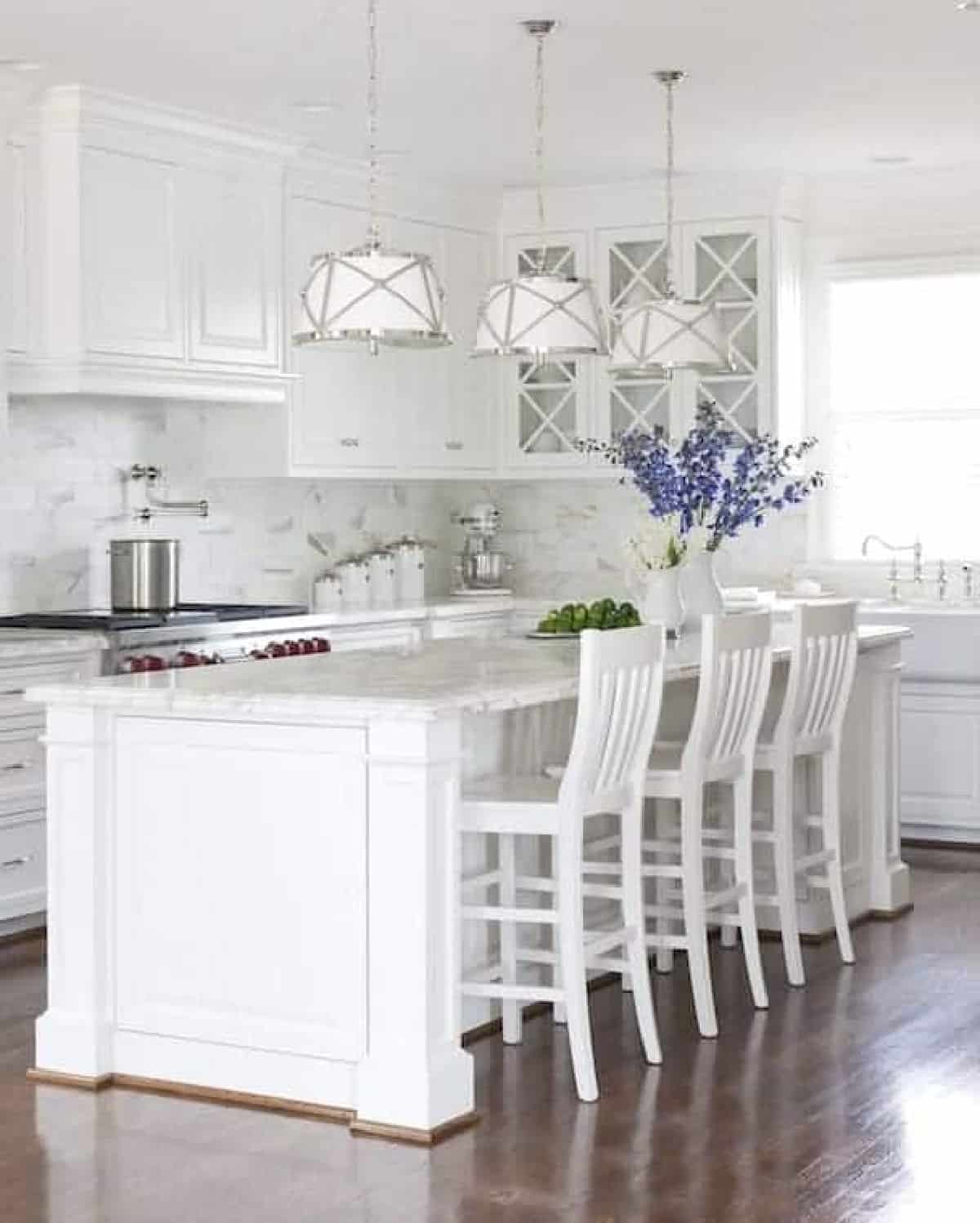 large white painted kitchen island with white chairs