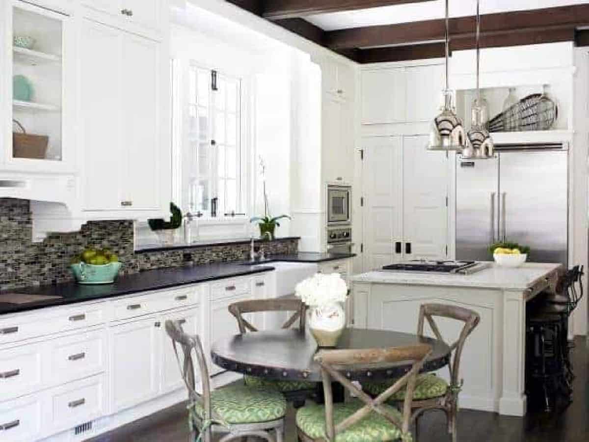 white kitchen with round wood table in the center