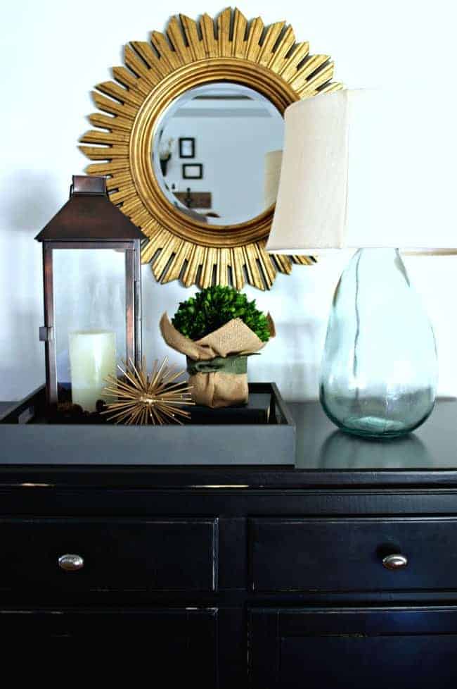 vignette on black console with lantern, lamp and greenery