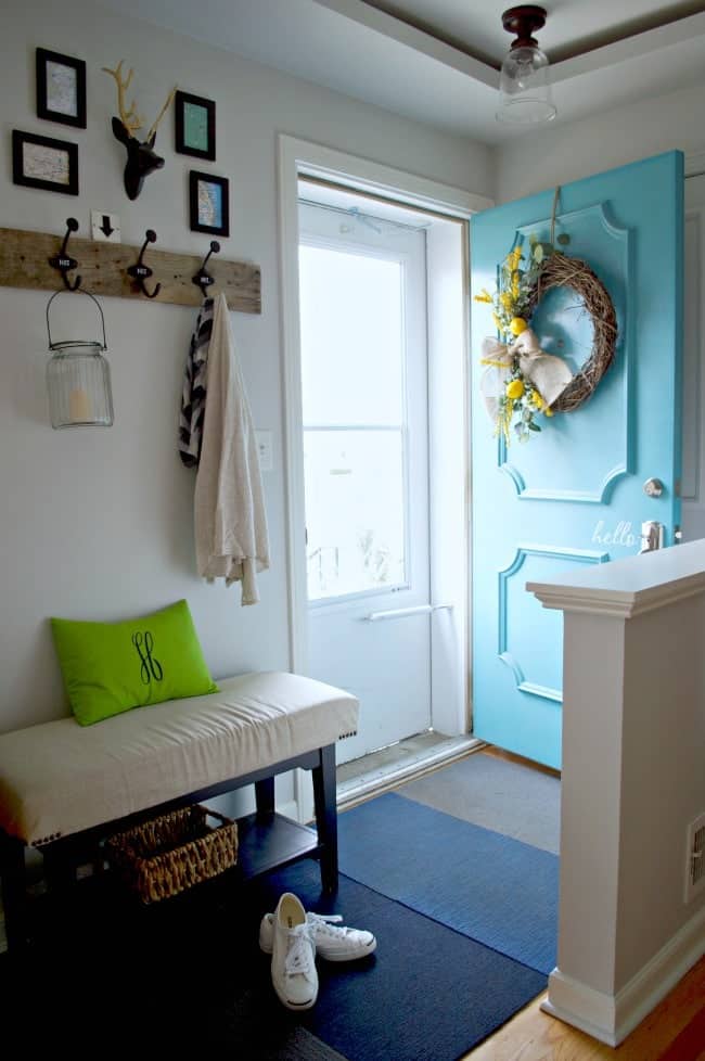 small entryway with turquoise front door and lemon wreath