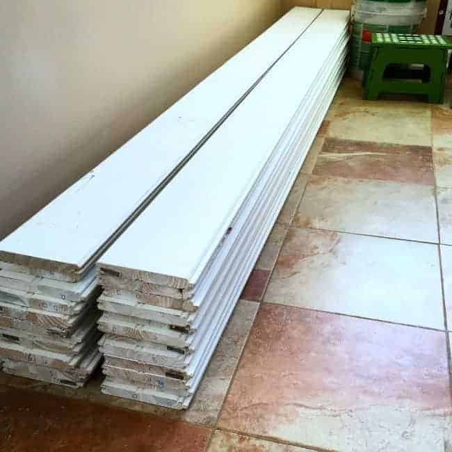 two stacks of tongue and groove planks on tiled kitchen floor