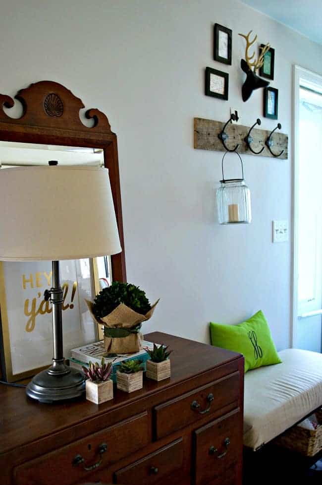 a small entryway with a dark wood cabinet and matching mirror