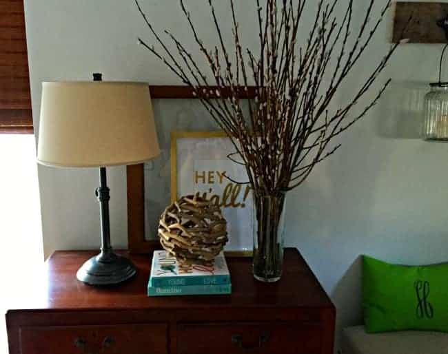 a vignette with a lamp on a dark wood cabinet