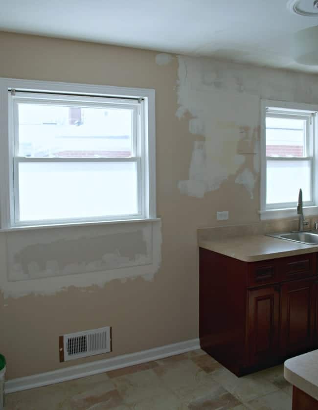 empty kitchen wall with spackle and paint swatches