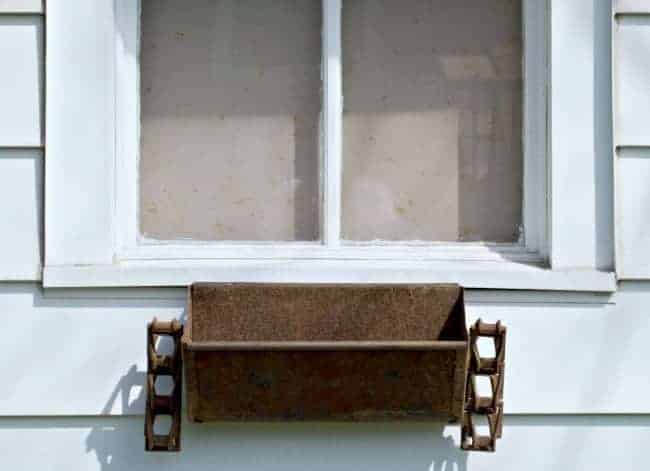 rusty flower box hanging on garage window