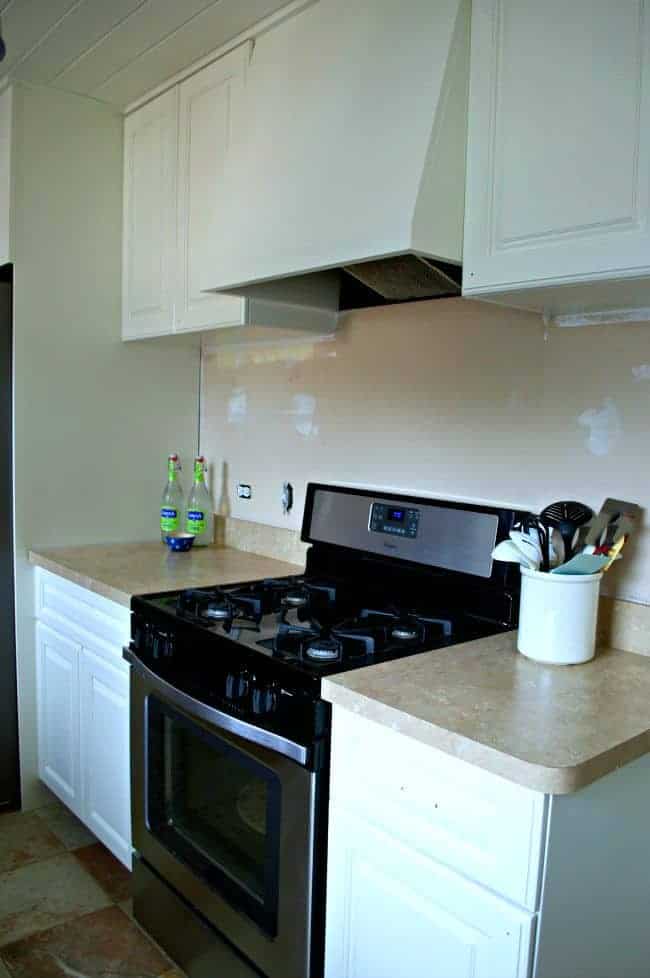 white painted kitchen cabinets and a stainless steel stove