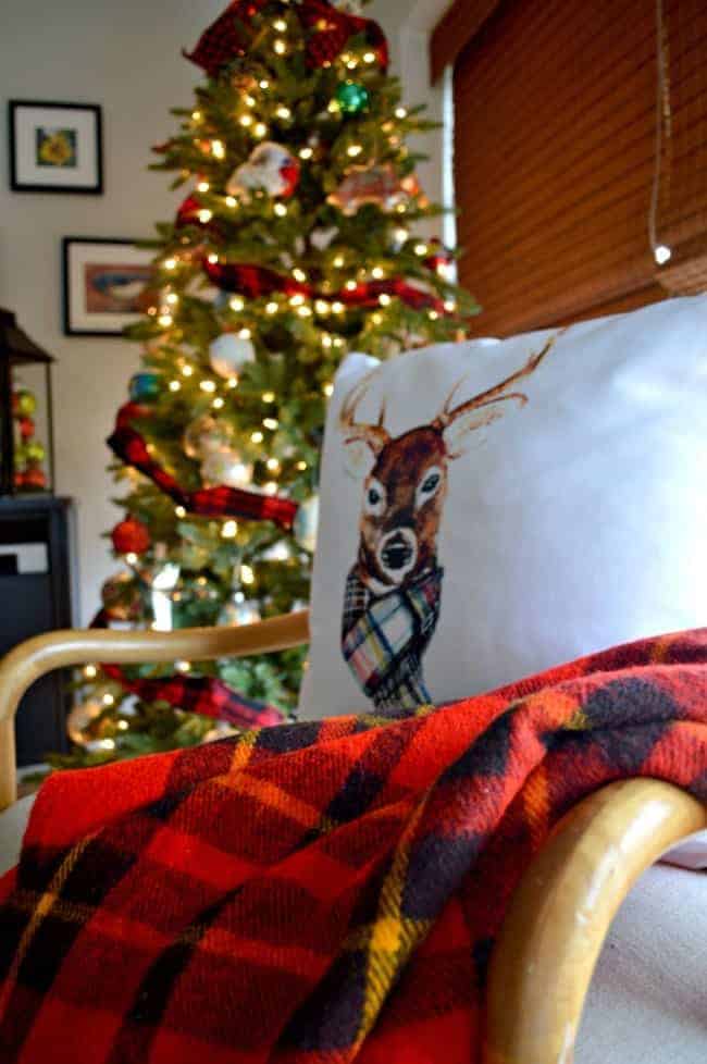 A Christmas living room decorated with lots of plaid, red and a reindeer pillow. | www.chatfieldcourt.com