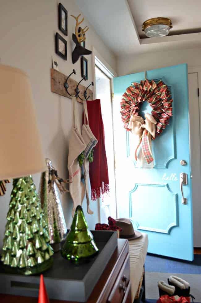 A Christmas living room decorated with lots of plaid, red, and a front door wreath with a burlap bow. | www.chatfieldcourt.com