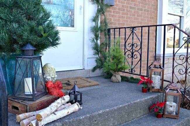 Christmas on our small front porch, which is decorated with greens, birch logs and a live mini Christmas tree | www.chatfieldcourt.com