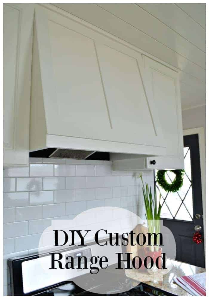 White painted DIY range hood over stainless steel stove with a subway backsplash