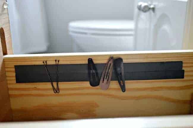 A magnetic strip that holds bobby pins helps with bathroom organization 