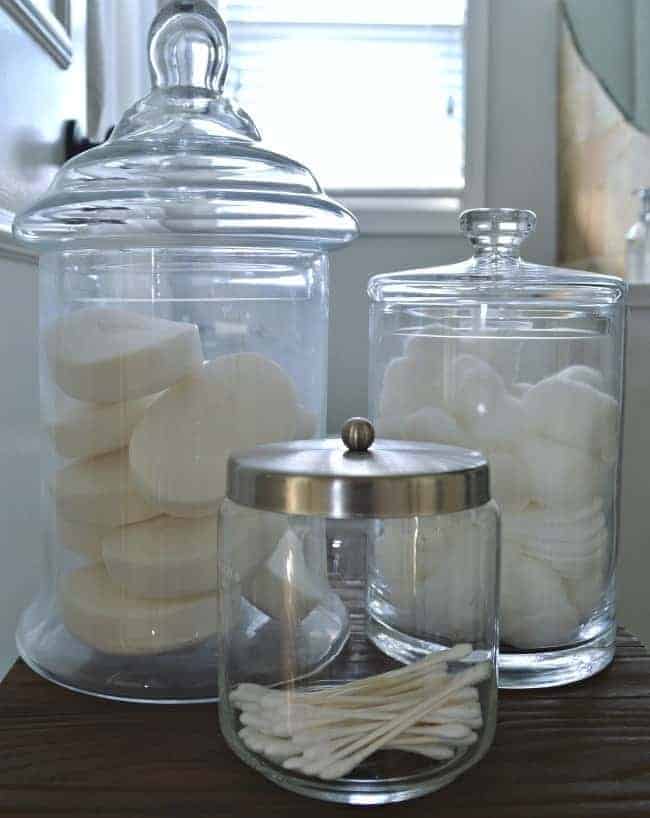 Using glass apothecary jars helps with bathroom organization 