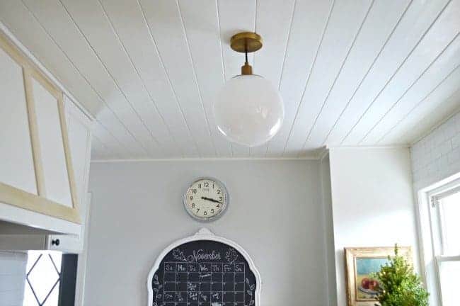 kitchen ceiling pendant and chalkboard with a clock over it