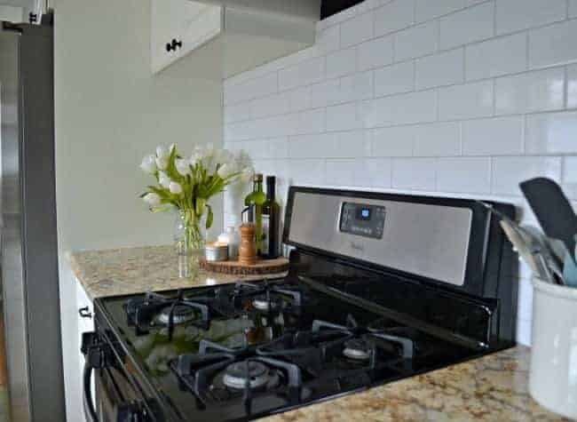 stainless steel stove in white kitchen with subway tile backsplash