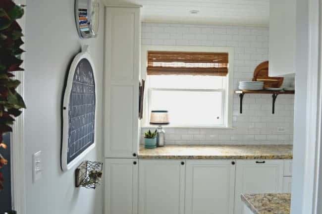 view of white kitchen cabinets and DIY chalkboard