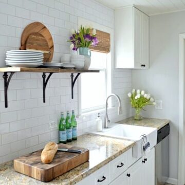 A white kitchen with a sink and a window