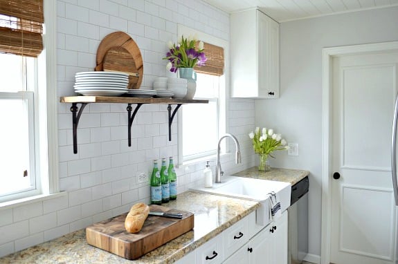 A white kitchen with a sink and a window