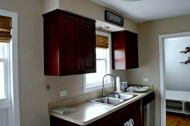 cherry kitchen cabinets and laminate countertop with window over kitchen sink