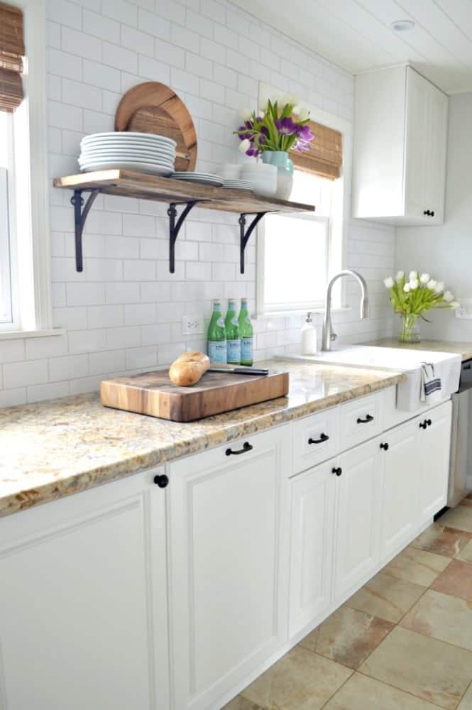 A white kitchen with a sink and a window