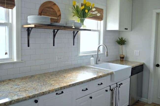 small galley kitchen with white cabinets and granite countertop 
