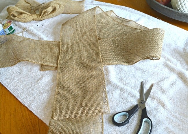 burlap ribbon and scissors laying on white towel on table