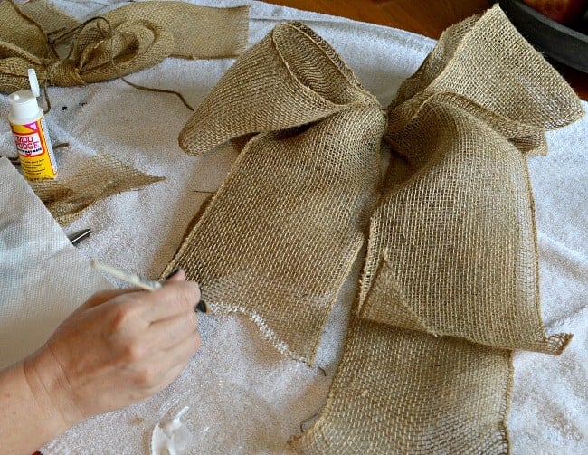 painting edges of burlap bow with Mod Podge 