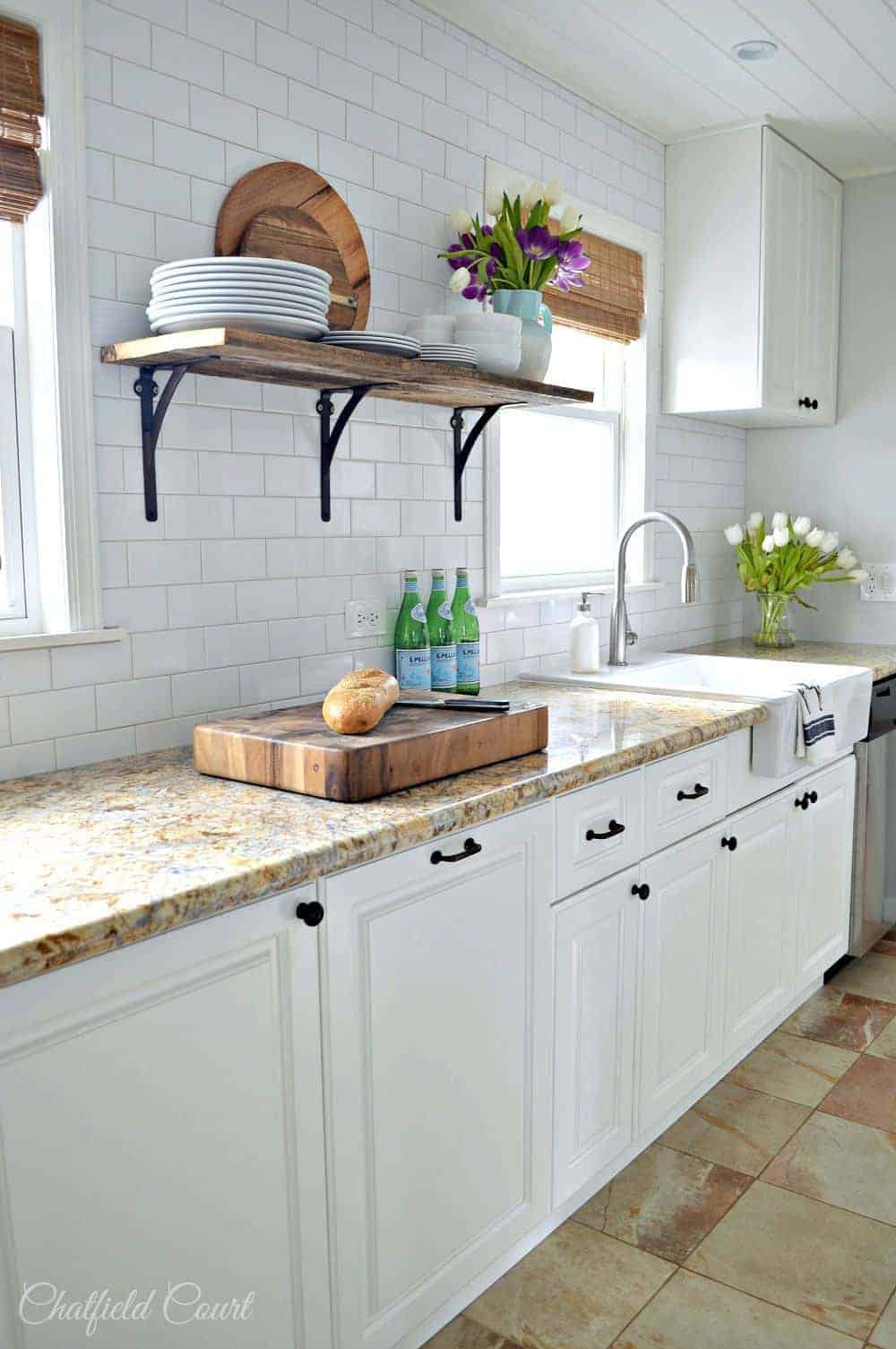 view of white kitchen cabinets with granite countertops after kitchen remodel