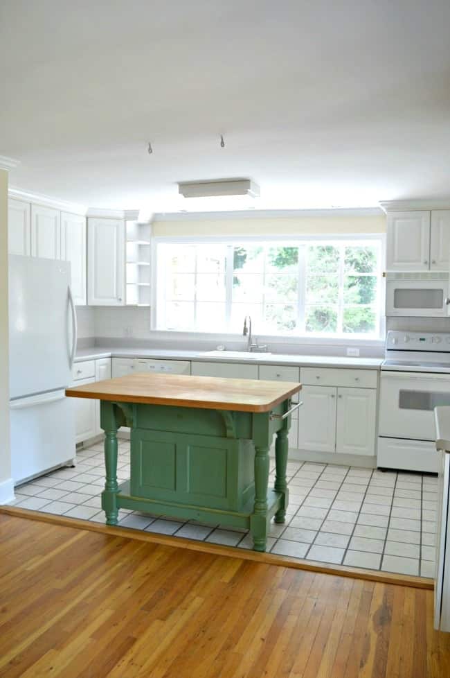 A kitchen with a green island