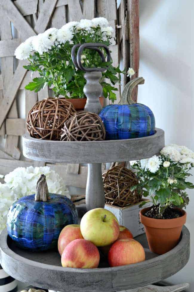 blue plaid pumpkins on 2 level tray with apples and other fall decor