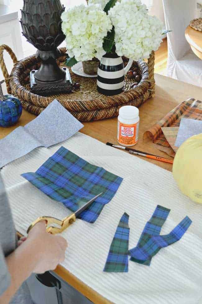 cutting strips of blue plaid wrapping paper