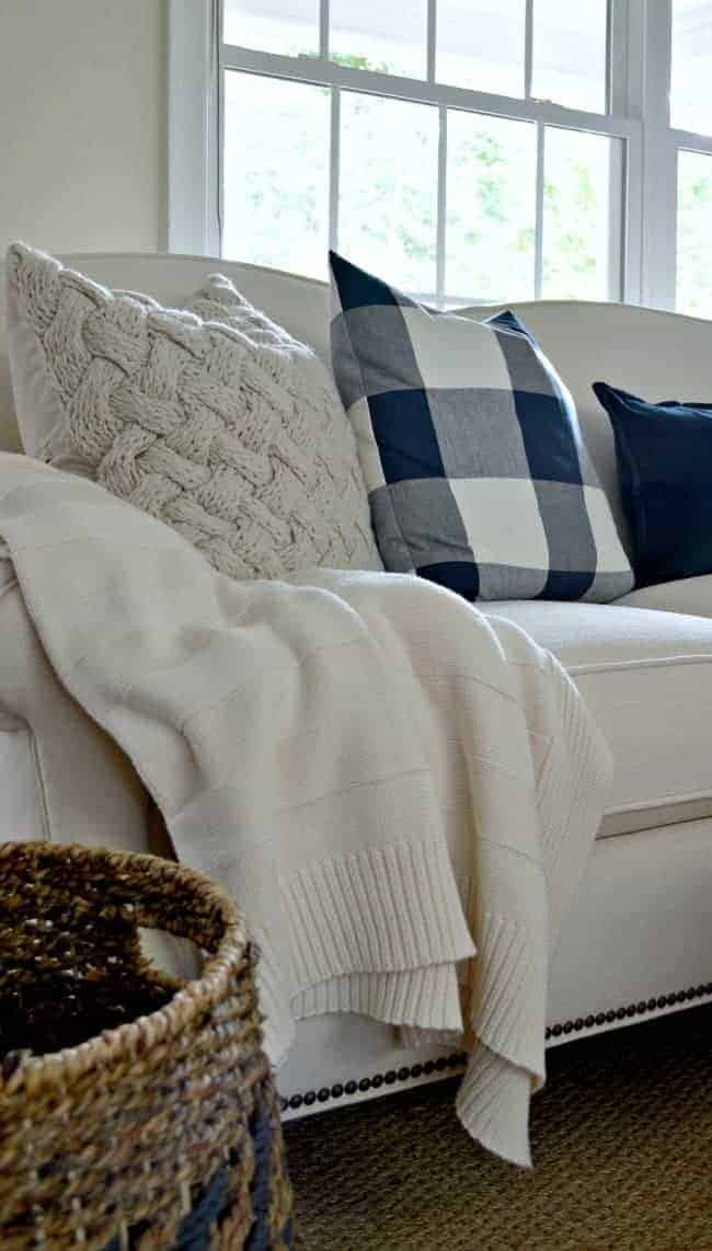 navy checked and knitted pillows on new white sofa