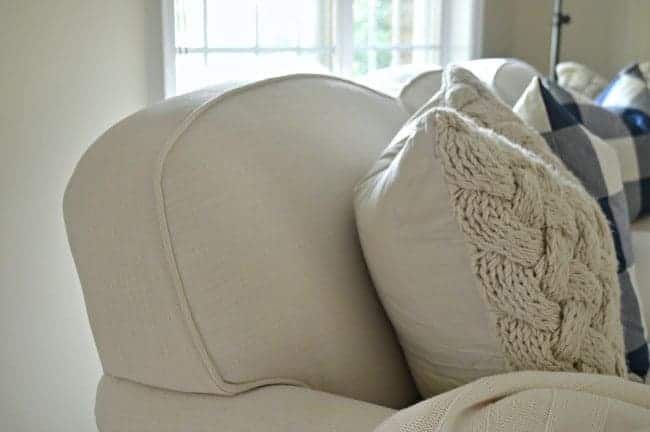 view of back cushions on new sofa and a knitted pillow