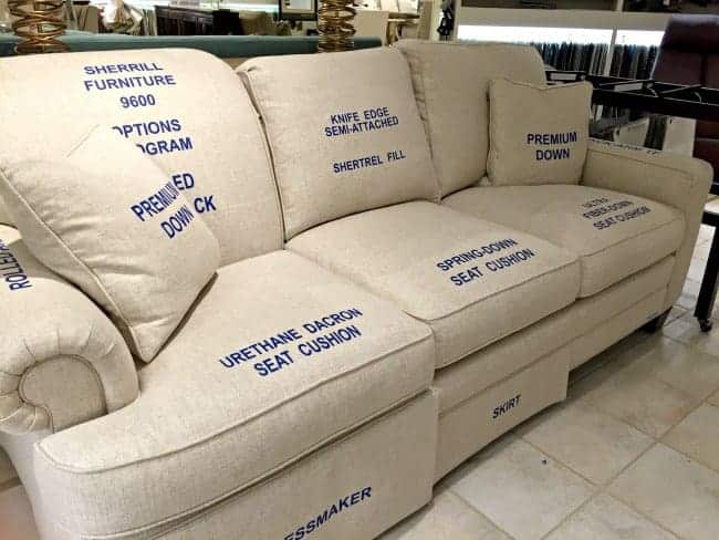 a couch display in a furniture store with labeled seat cushions