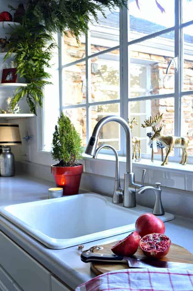 The kitchen in our rustic and simple cozy Christmas cottage decorated in red with touches of live greenery. www.chafieldcourt.com 