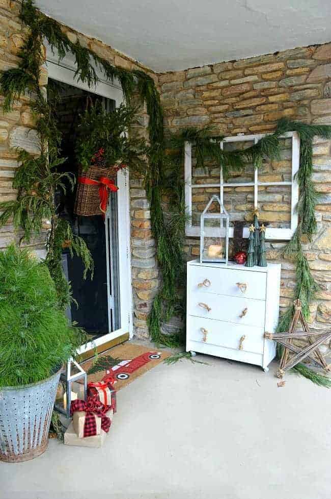 Decorating ideas for a cozy Christmas porch using fresh garland, candles and a few rustic touches. www.chatfieldcourt.com 