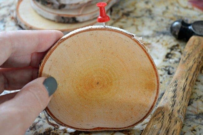 pushpin stuck in top of wood slice