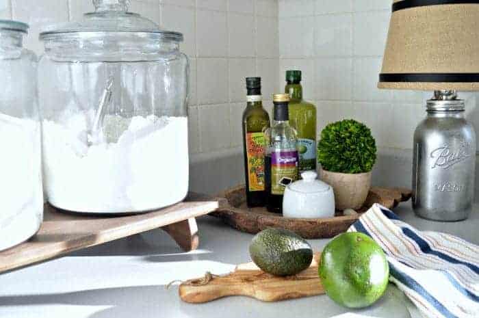 large glass jars with sugar and flour in them plus wood tray with cooking oils